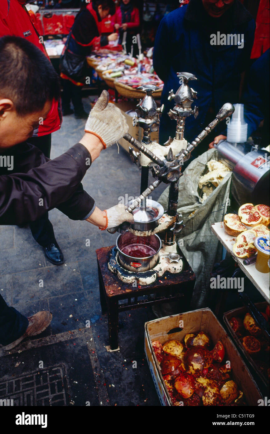 Venditore ambulante di spremitura della frutta melograno per il succo di frutta, Citta' di Xian, Cina Foto Stock