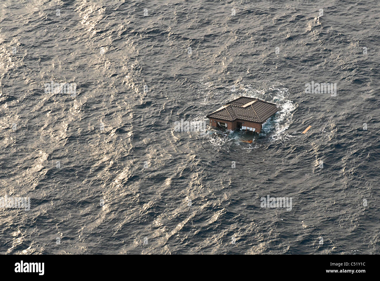 Vista aerea di casa alla deriva nell'Oceano Pacifico a seguito di un forte terremoto e tsunami in Giappone. Foto Stock