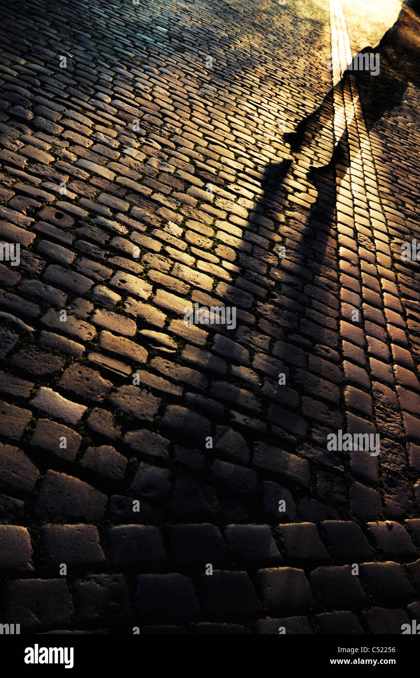 Camminando su una strada di ciottoli di notte Foto Stock