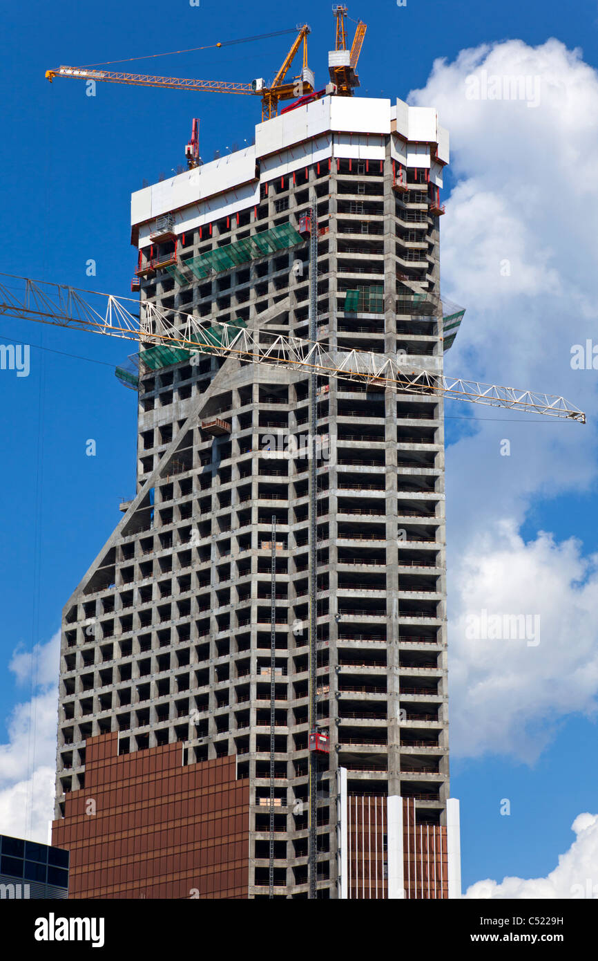 La costruzione di un grattacielo sul cielo blu sullo sfondo. Foto Stock