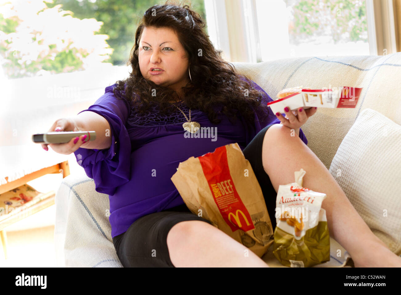 Donna di mangiare cibo grasso Foto Stock