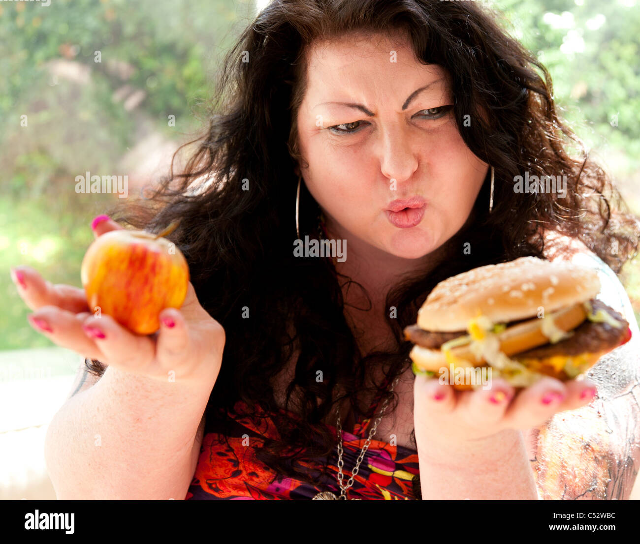 Donna di mangiare cibo grasso Foto Stock