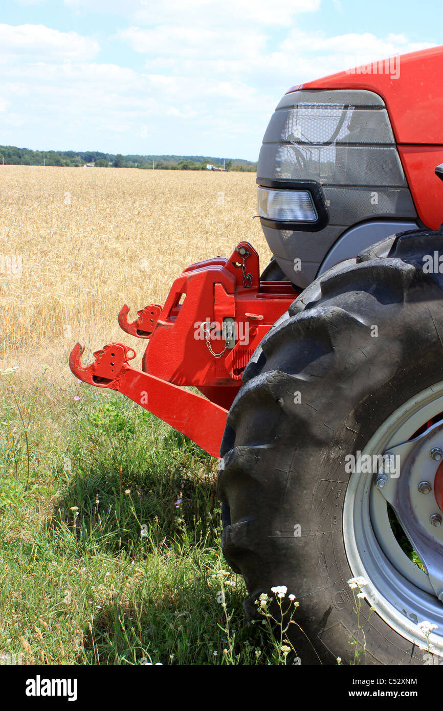La parte anteriore di un trattore per l'agricoltura sullo sfondo un campo di grano Foto Stock