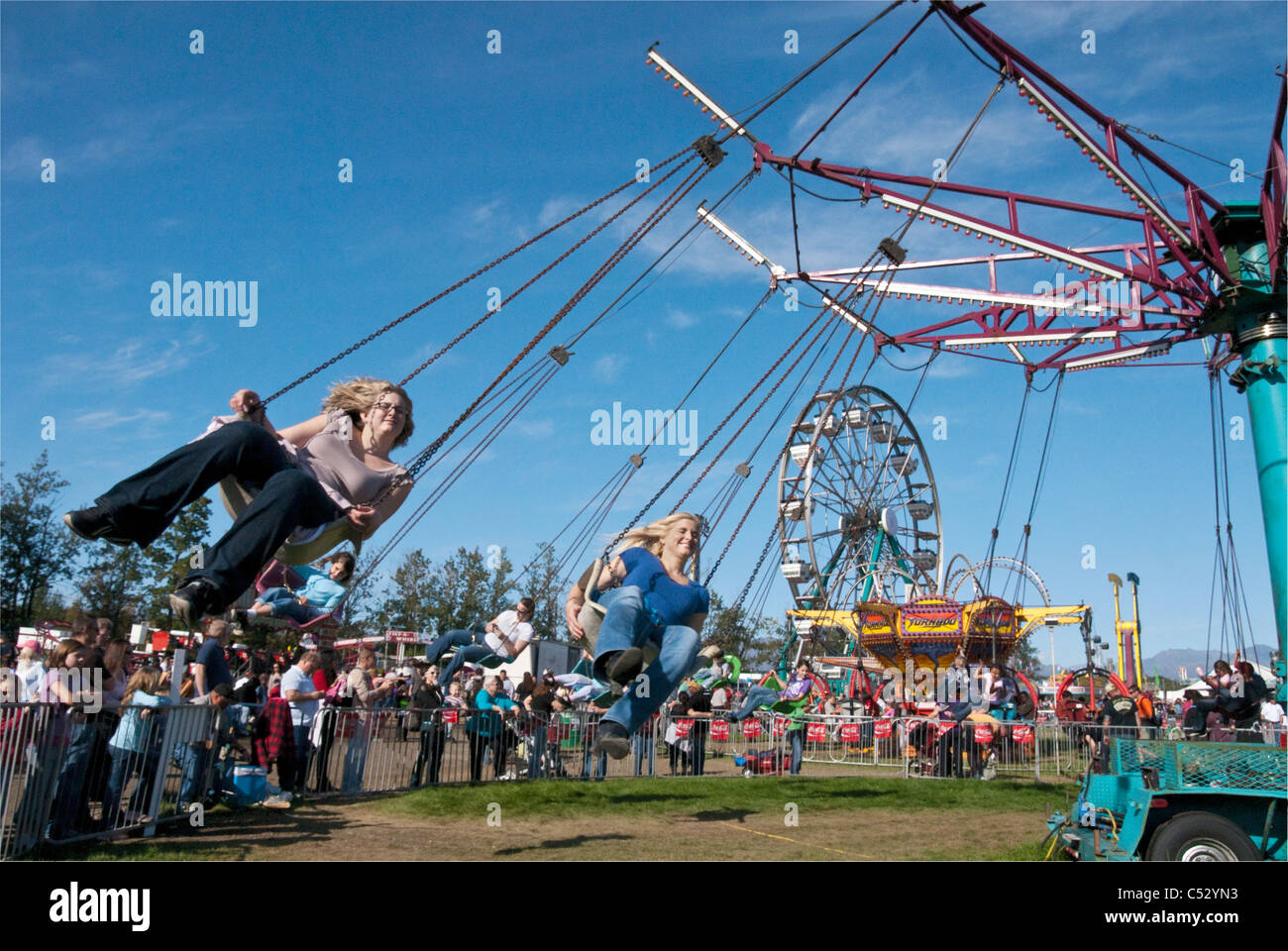 Persone a cavallo il parco dei divertimenti di corsa di oscillazione in Alaska State Fair in Palmer, centromeridionale Alaska, Autunno Foto Stock