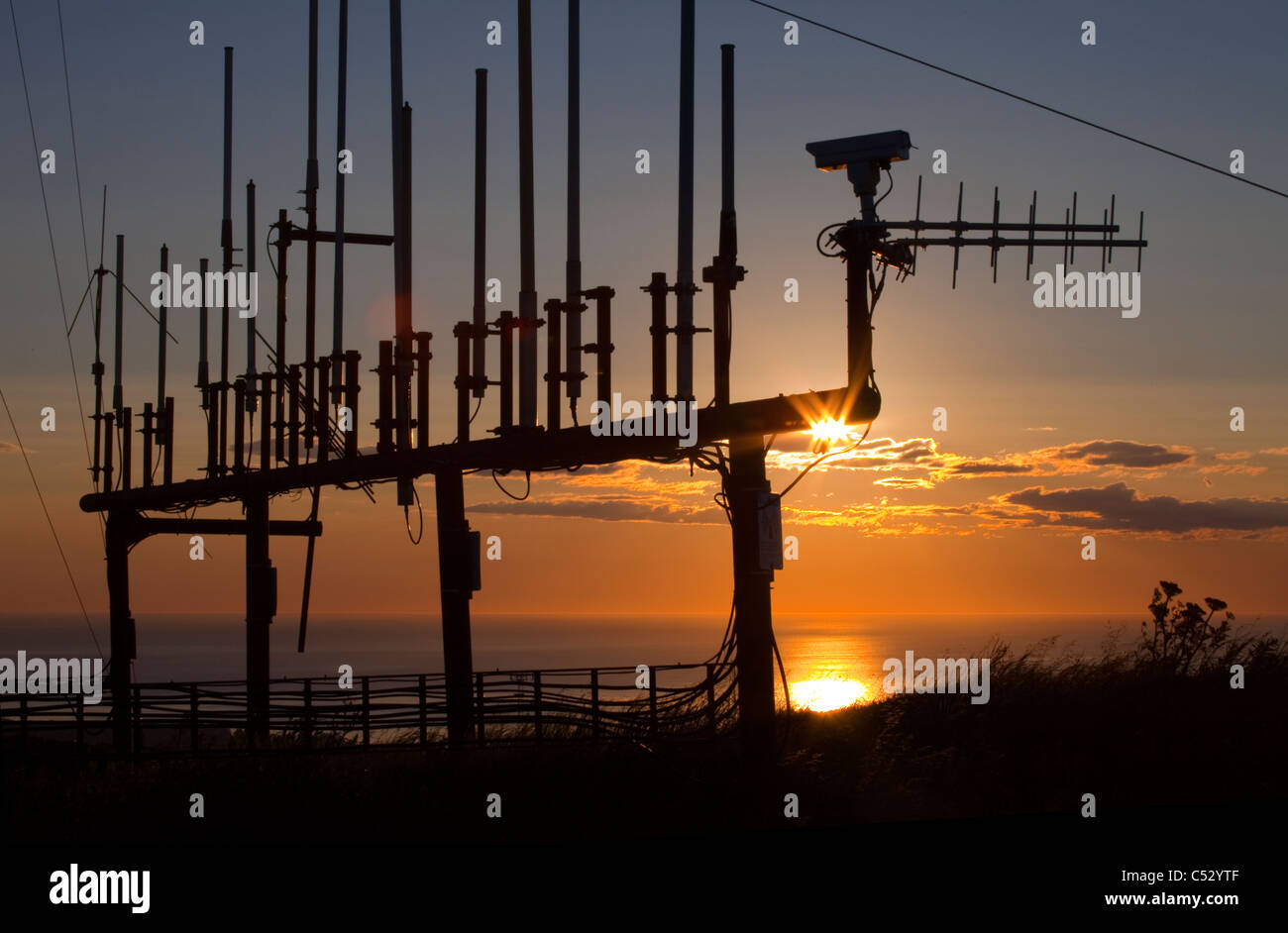 Guardando a nord-est di sunrise attraverso due vie sistema radio antenne sulla sommità del pilastro montagna, Kodiak, Southwest Alaska, estate Foto Stock