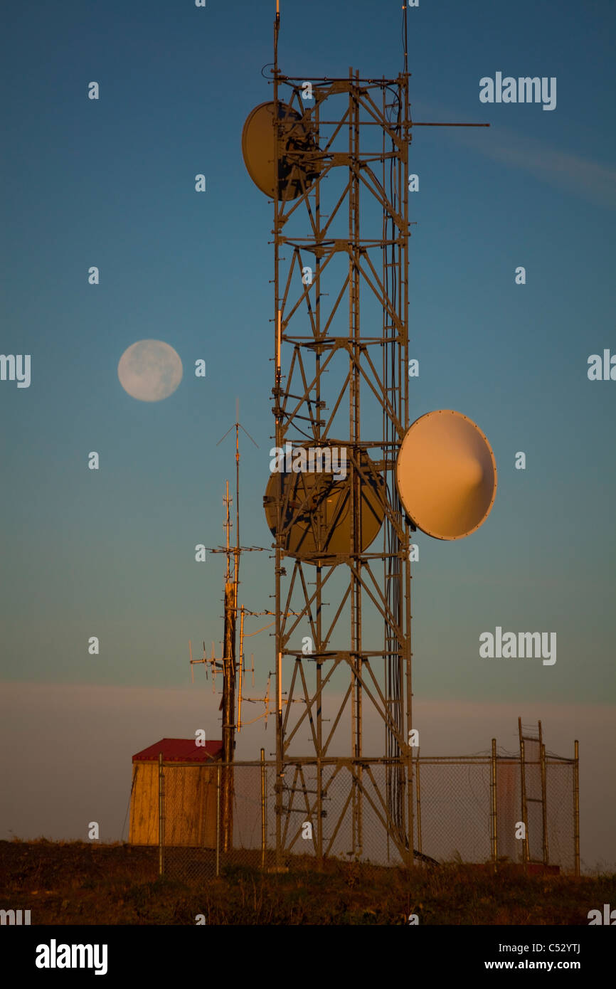Torre della radio, contenente USCG VHF-FM rete con la luna piena in background di sunrise, pilastro montagna, isola di Kodiak, Alaska Foto Stock