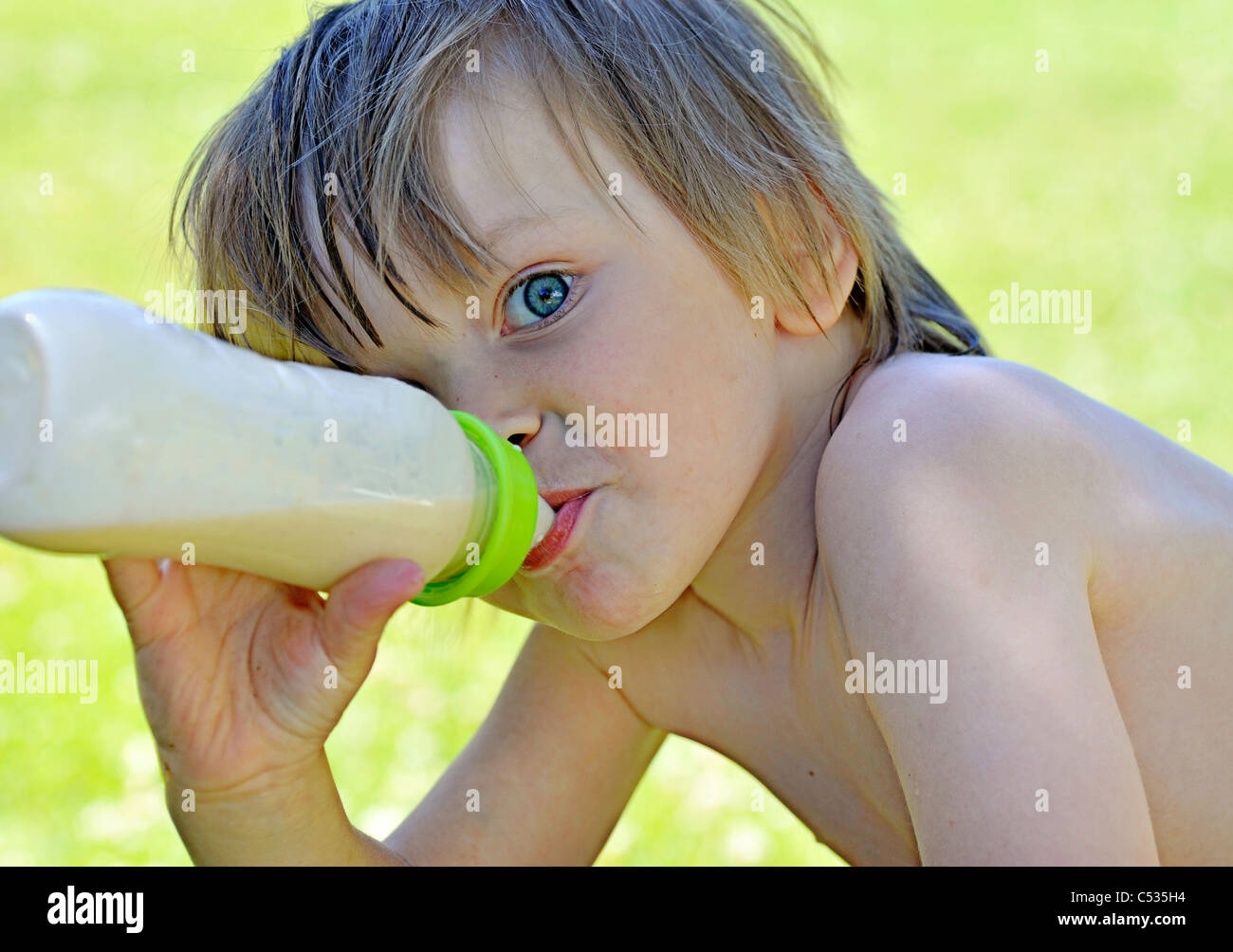 Ragazzo giovane mangiare gruel da un vaso di alimentazione Foto Stock