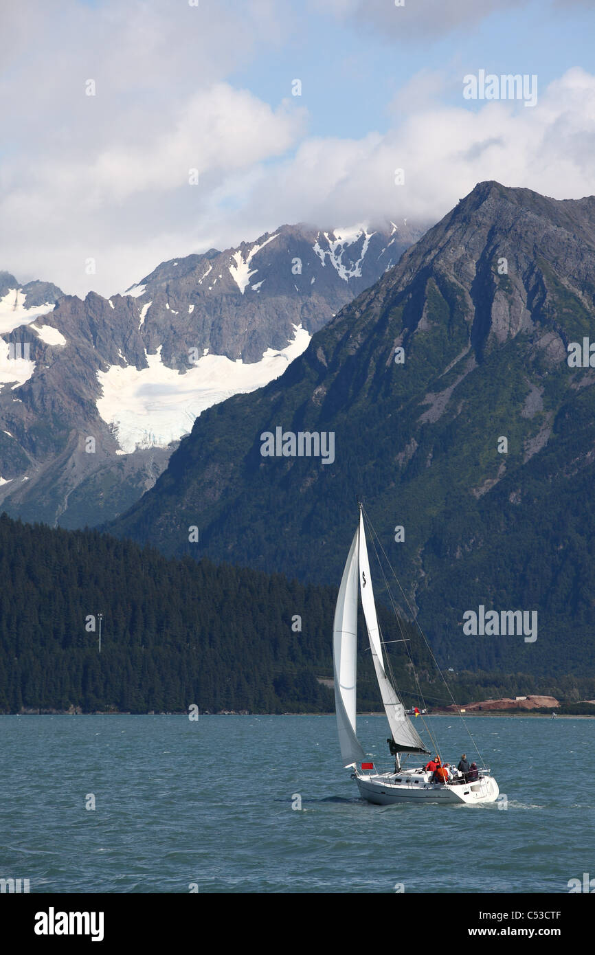La gente in barca a vela nella risurrezione baia vicino a Seward con Kenai Mountains in background, centromeridionale Alaska, estate Foto Stock