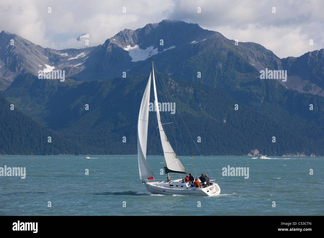 La gente in barca a vela nella risurrezione baia vicino a Seward con Kenai Mountains in background, centromeridionale Alaska, estate Foto Stock