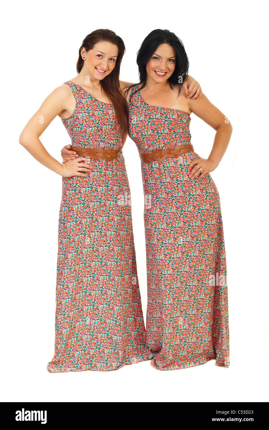 Felice belle sorelle che indossa lo stesso abito e in piedi di abbracciare isolati su sfondo bianco Foto Stock