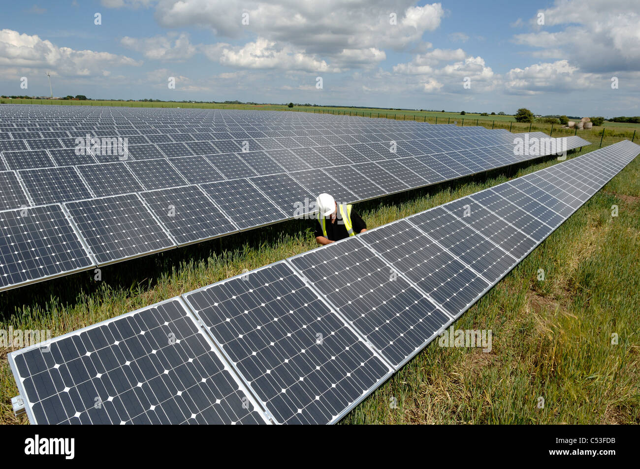 UKs prima solar electric power station in costruzione a Fen Agriturismo vicino a Louth Lincolnshire e ecotricity wind farm dietro Foto Stock