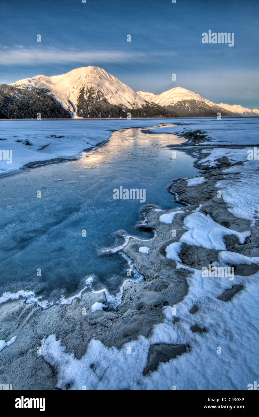 La luce del mattino sulla Kenai Mountains riflette sulle acque e ghiaccio di Turnagain Arm, centromeridionale Alaska, l'inverno. HDR Foto Stock