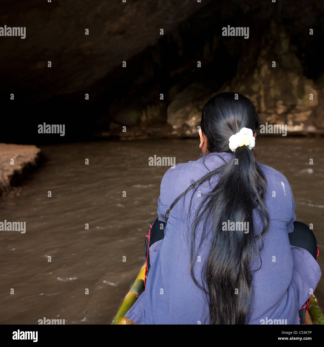 Vista posteriore di una donna seduta su una barca di bambù, Thailandia Foto Stock