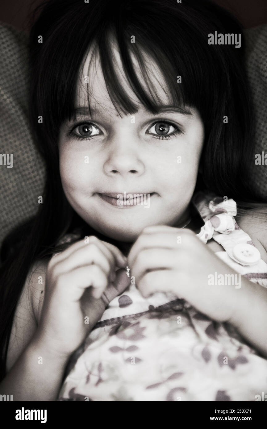 Stupendo bambino seduto su un lettino è sorridente alla fotocamera, lasciando che il fotografo scatta un ritratto Foto Stock