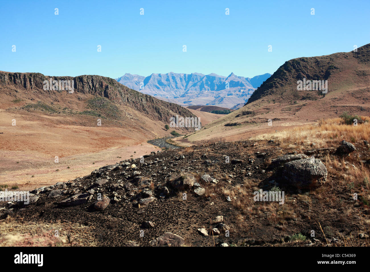 Un flusso si snoda attraverso una gola ai piedi delle colline di southern Drakensberg. Sud Africa. Foto Stock