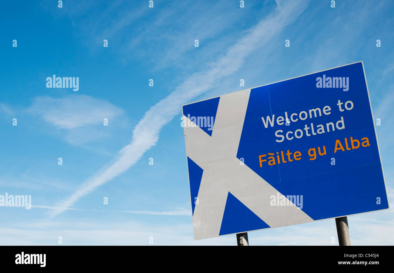 Scozia segno di confine al confine di Northumberland davanti a una croce bianca piano trail nel cielo blu Foto Stock