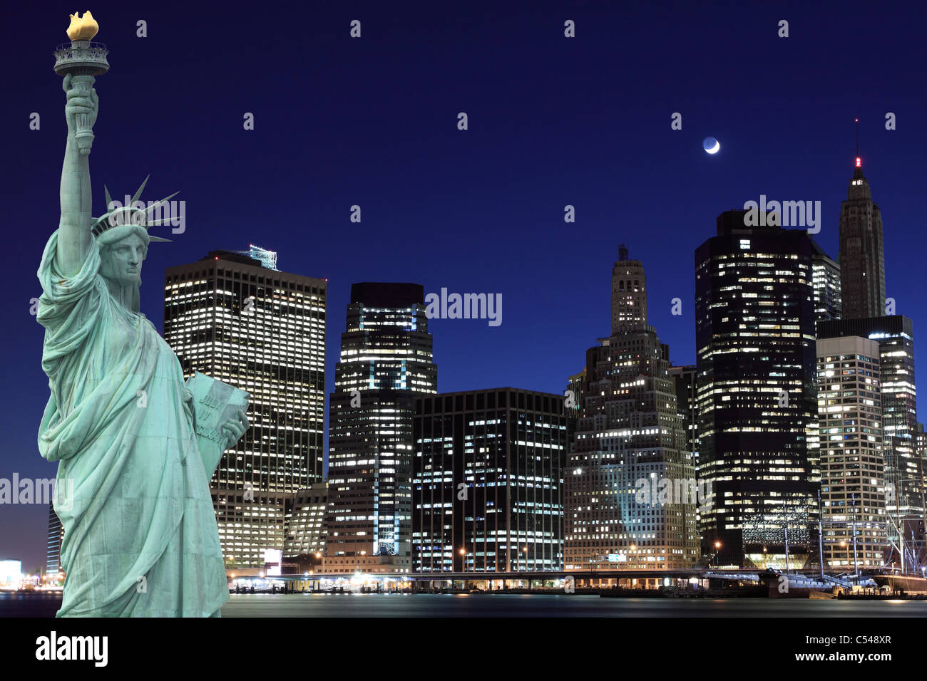 Skyline di Manhattan e la statua della libertà di notte le luci di New York City Foto Stock