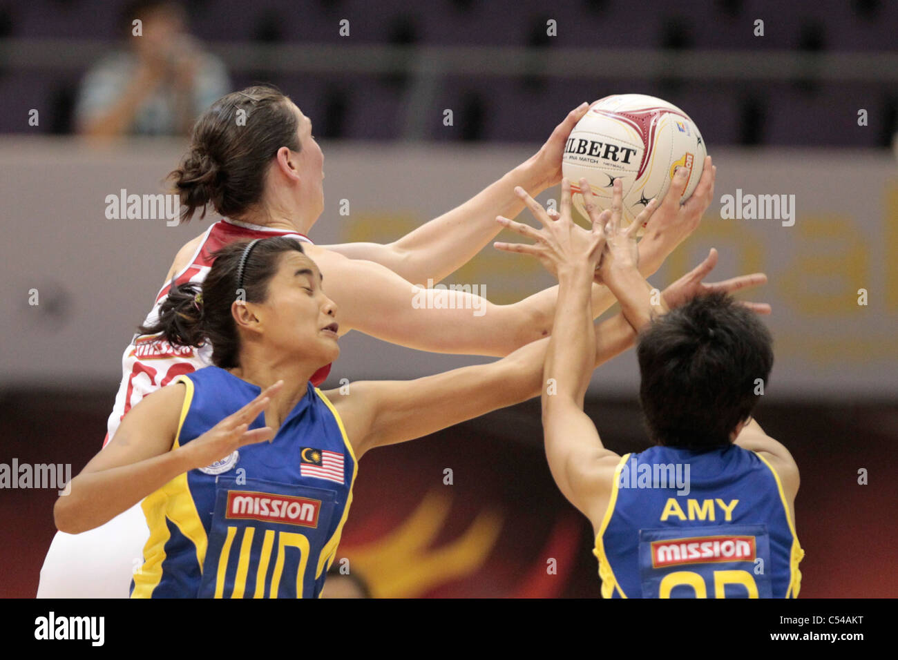 06.07.2011 Rachel Dunn di Inghilterra(rosso) battaglie per la sfera durante il Pool D match tra Inghilterra vs Malaysia, Mission Foods World Netball Championships 2011 dal Singapore Indoor Stadium di Singapore. Foto Stock