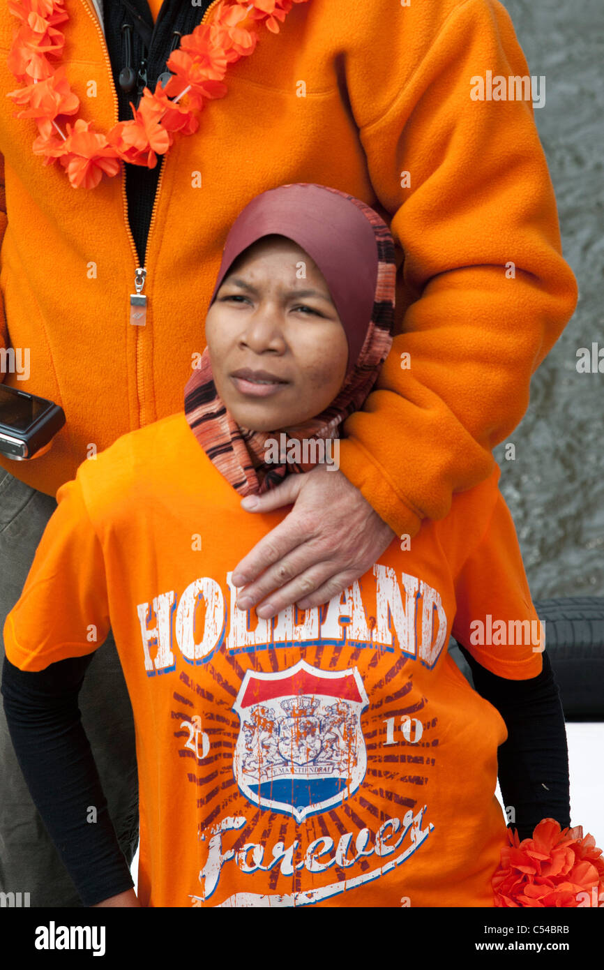 Festival annuale il 30 Aprile per festeggiare il compleanno della regina. La donna da decente indonesiano in arancione Holland T-shirt. Foto Stock