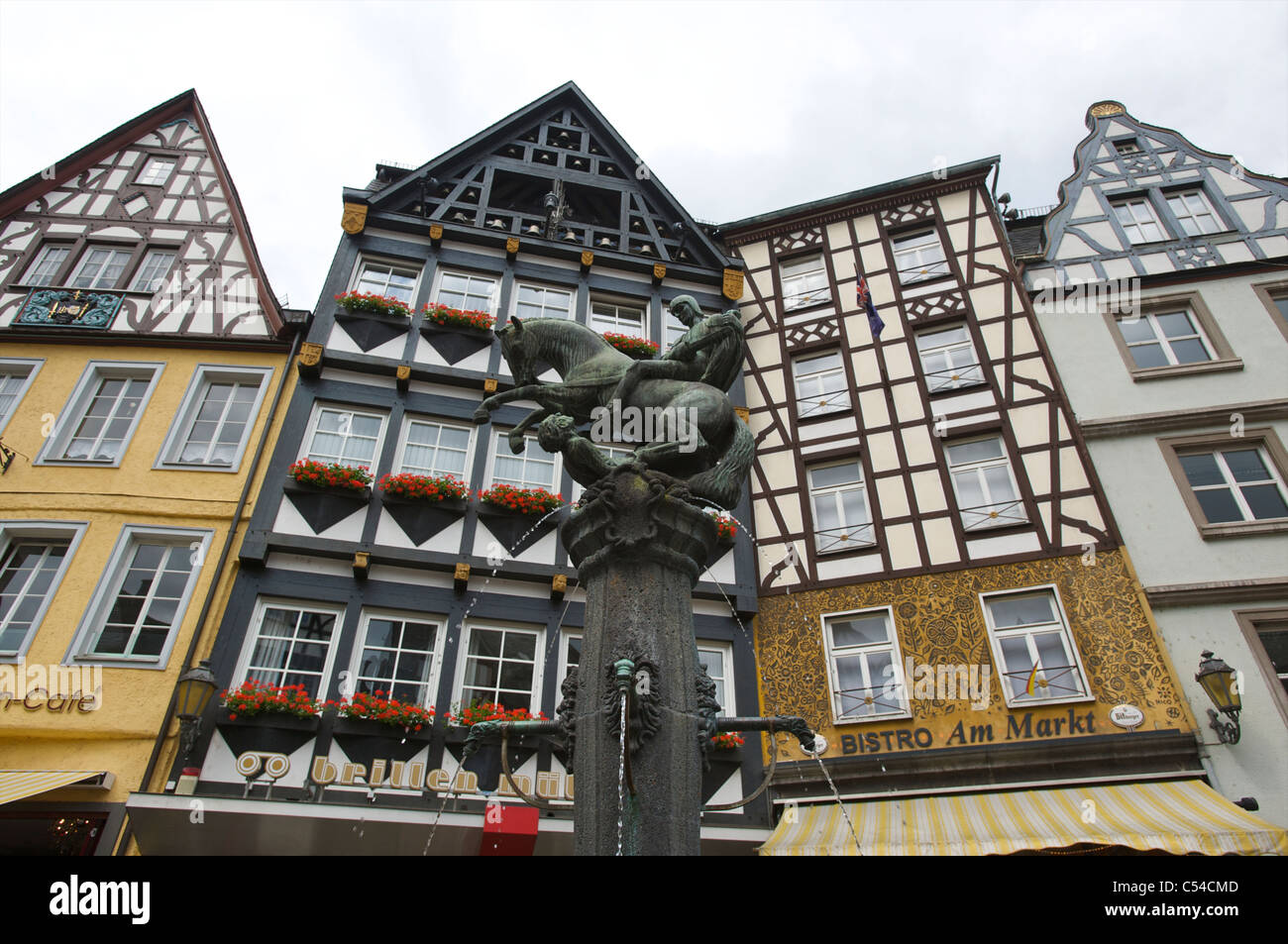 Basso angolo vista di semi-case di legno con una fontana presso la piazza del mercato di Cochem, Renania-Palatinato, Germania Foto Stock