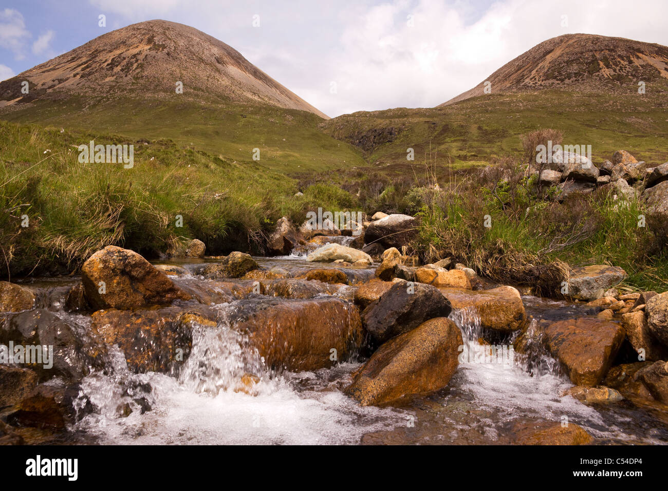 Tumbling flusso di Allt Slapin sotto due Red Cuillin picchi di montagna, Isola di Skye, Scotland, Regno Unito Foto Stock