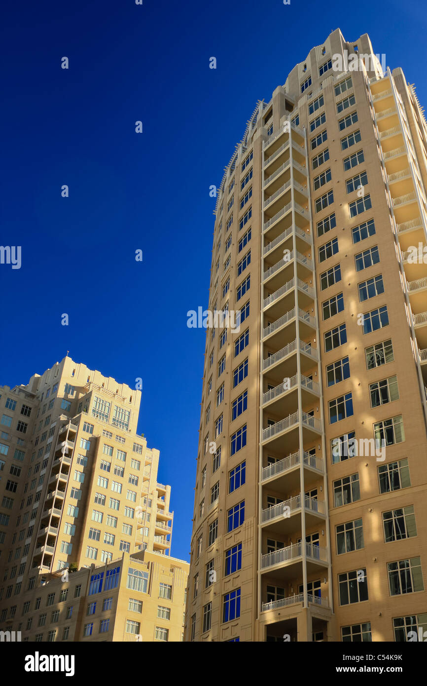 L'immagine verticale di due edifici ad alta nella prospettiva verso l'alto sparato contro un profondo cielo blu. Entrambe le torri includono cast-stone fa Foto Stock