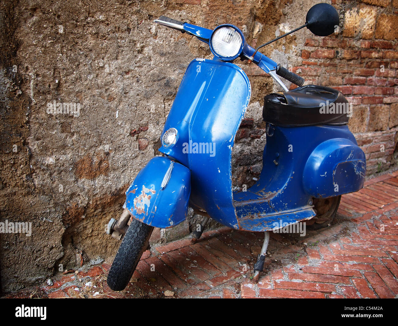 Italiano tipico stile retrò scooter parcheggiato di fronte a un muro di mattoni. Foto Stock