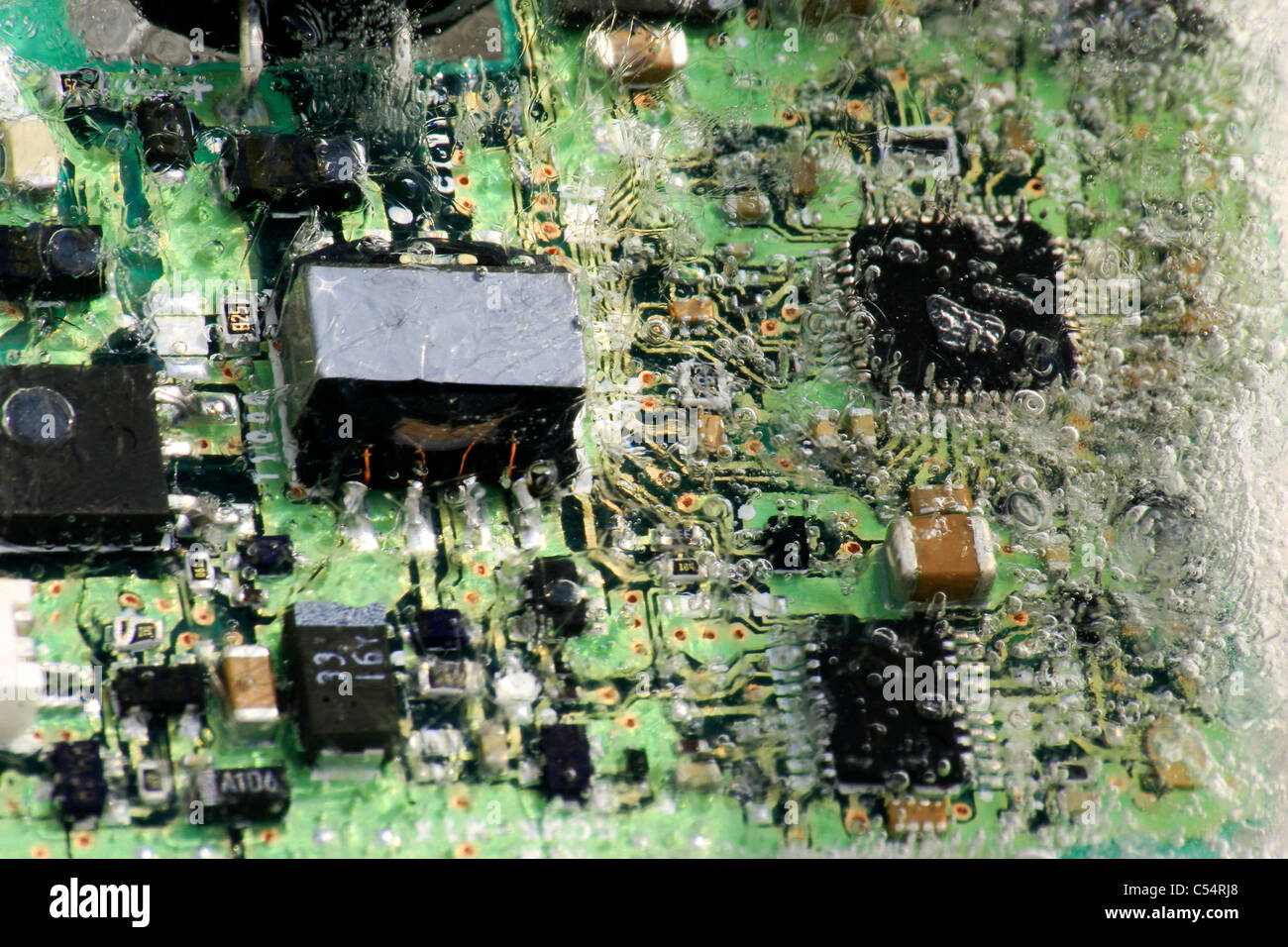 Una scheda di circuito elettronico congelato in un blocco di ghiaccio. Foto Stock