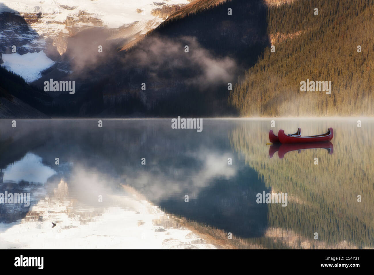 Canoa in un lago di sunrise, il Lago Louise, il Parco Nazionale di Banff, Alberta, Canada Foto Stock