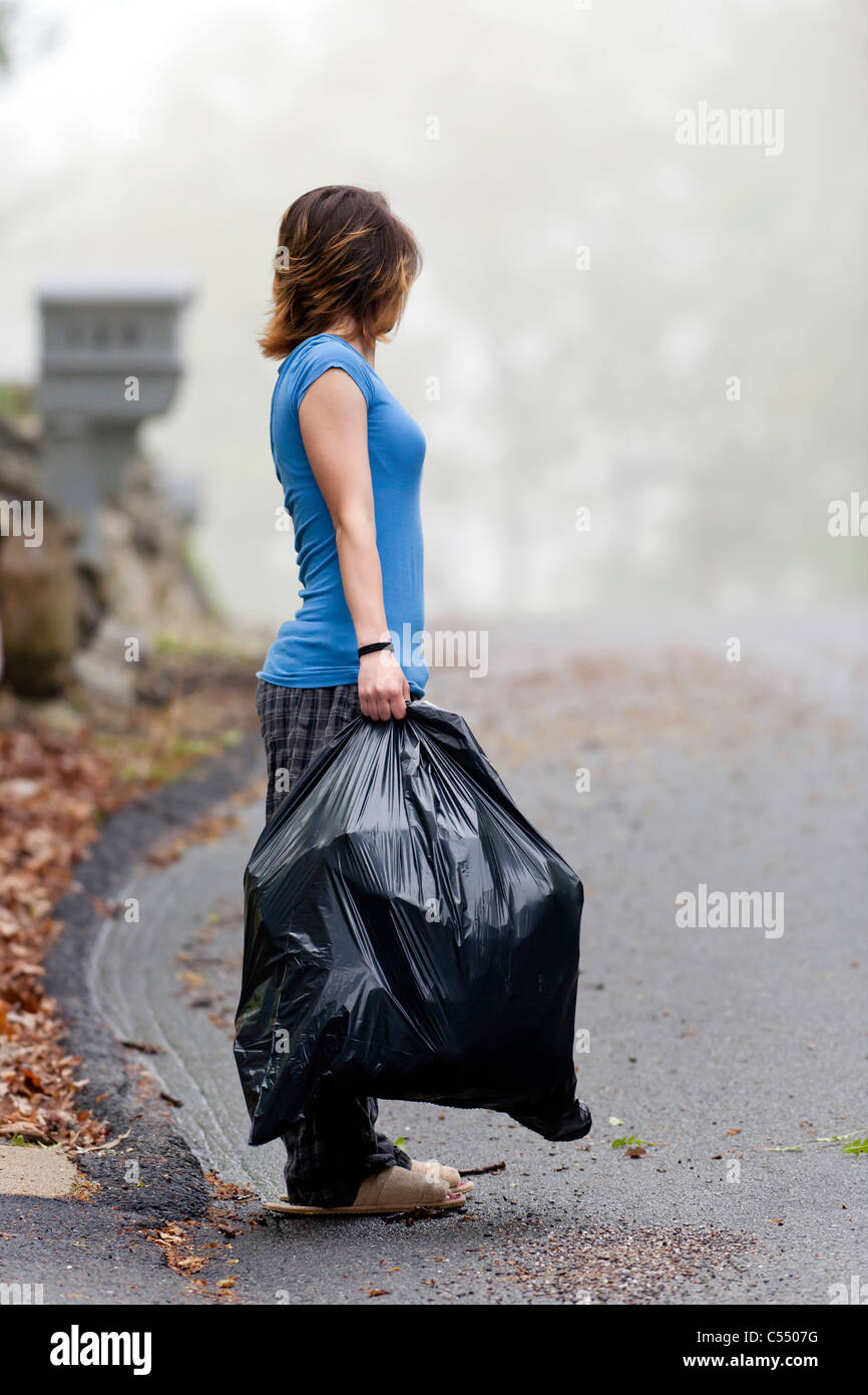 Ragazza adolescente in attesa di garbage l'uomo. Foto Stock