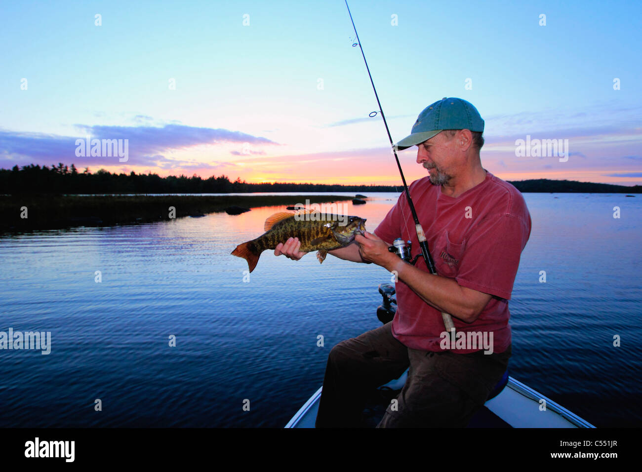 Uomo maturo Bass pesca in un lago Foto Stock