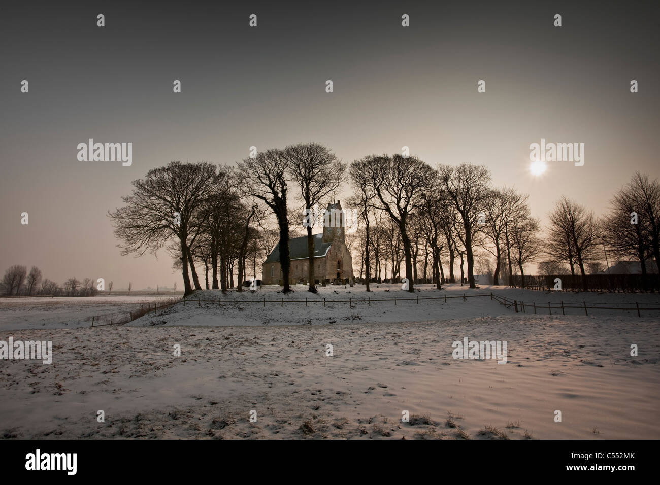 I Paesi Bassi, Hijum, Chiesa sul cumulo di neve a sunrise. Foto Stock