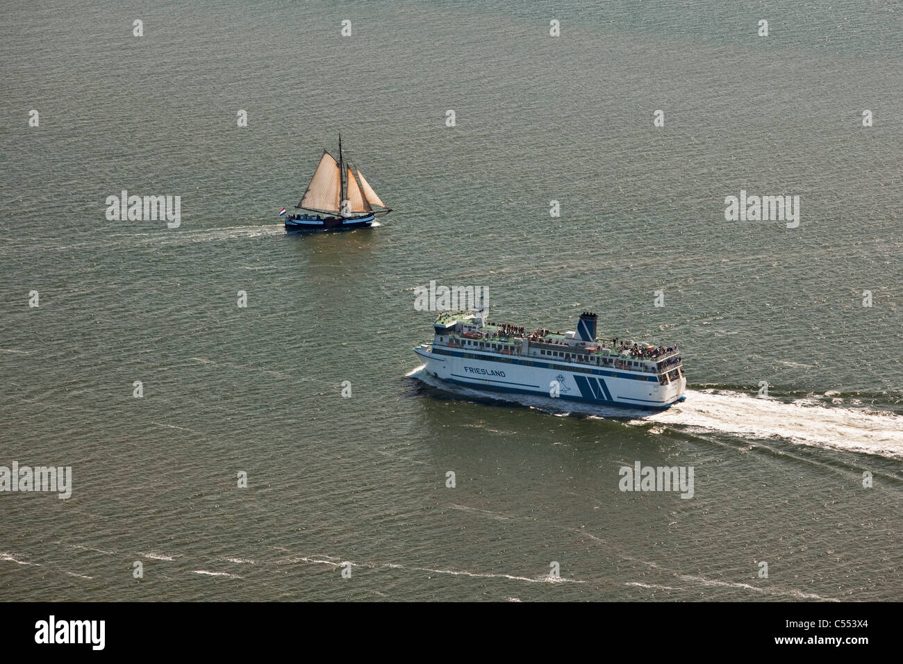 Paesi Bassi, Isola di Terschelling, il Wadden Sea. La bassa marea. Traghetto tradizionale e del carico della nave a vela, crociere turistiche. Antenna. Foto Stock