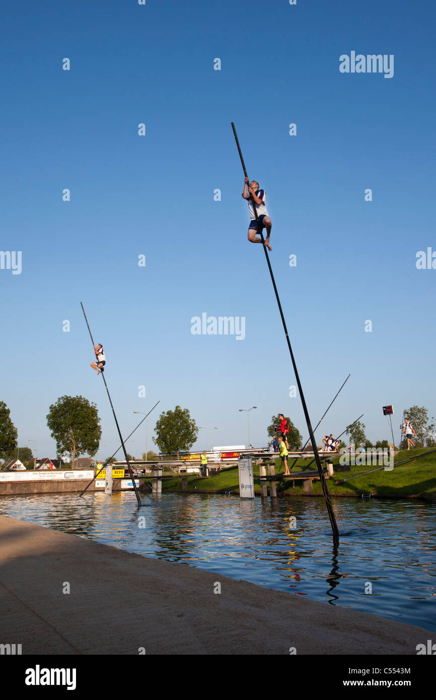 I Paesi Bassi, IJlst, concorrenza di fenpoling, localmente denominata Fierljeppen, attraversando l'acqua per quanto è possibile. Foto Stock