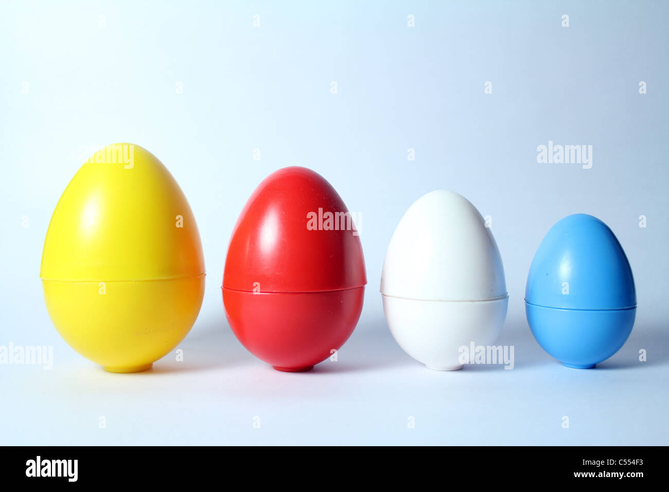 Inquadratura concettuale di uova di plastica di diverse dimensioni Foto Stock