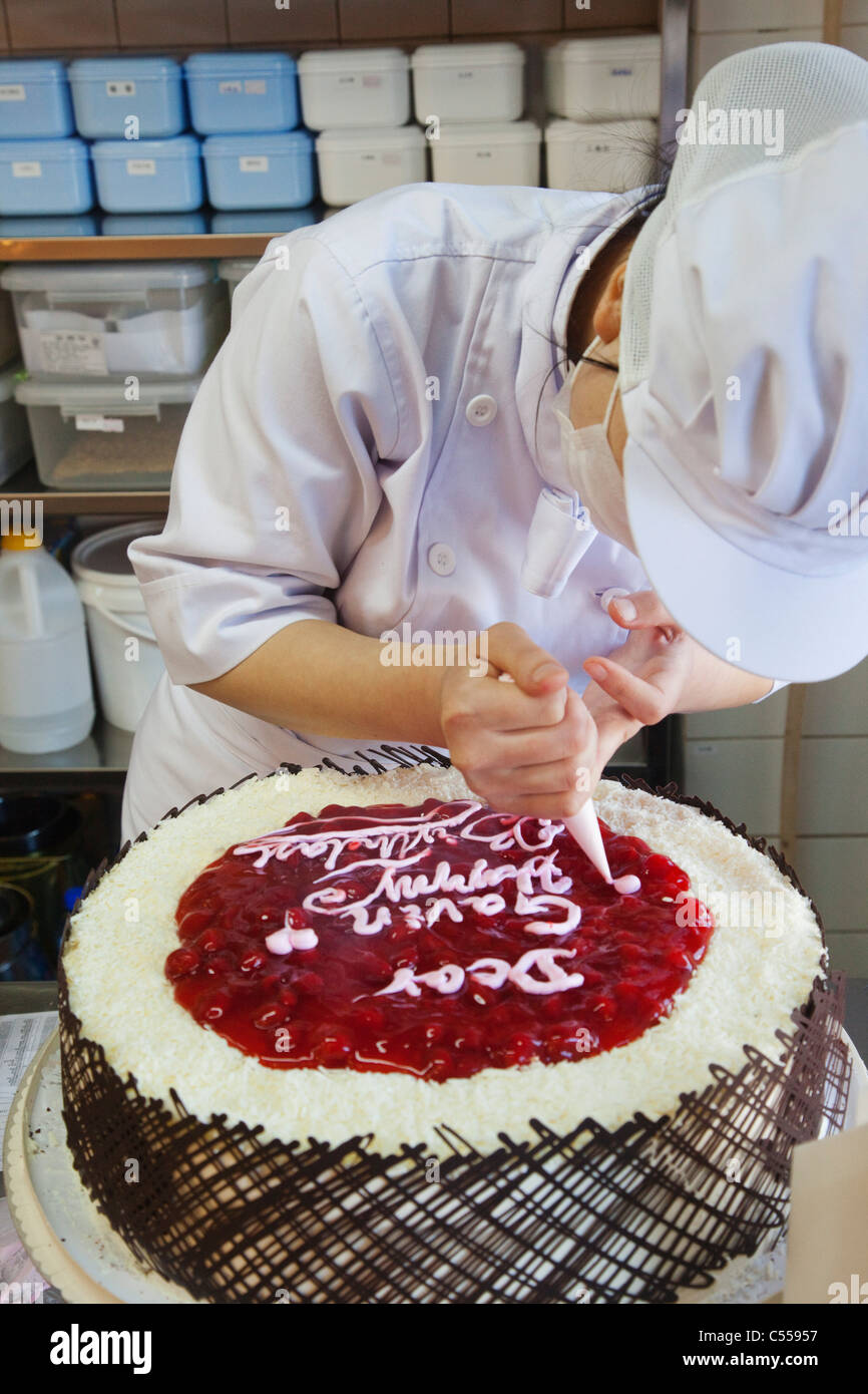 Lo chef femmina decorare una torta di compleanno a Pechino, Cina Foto stock  - Alamy