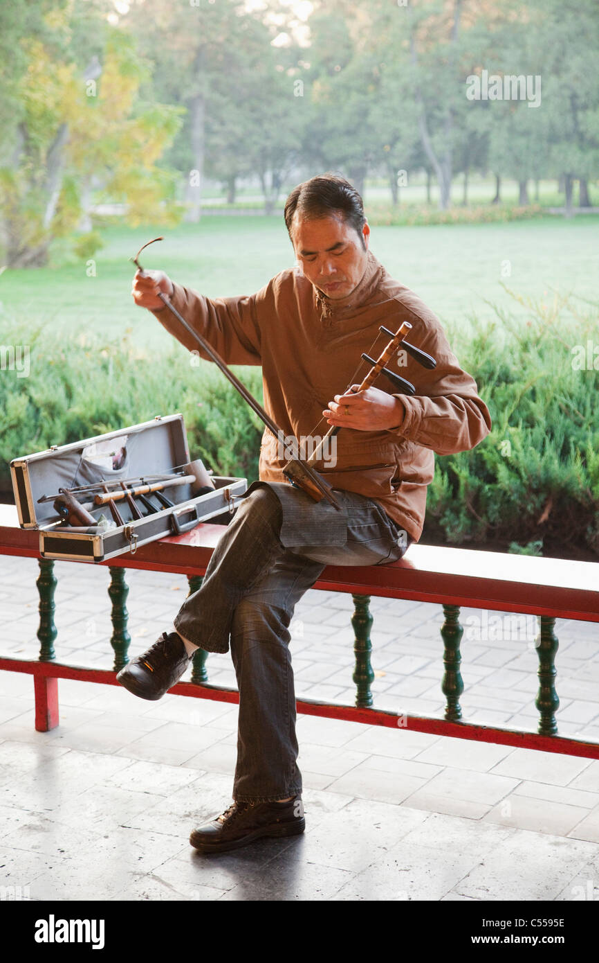 L'uomo gioca Erhu il cinese tradizionale strumento a corda, il Tempio del Cielo a Pechino, Cina Foto Stock