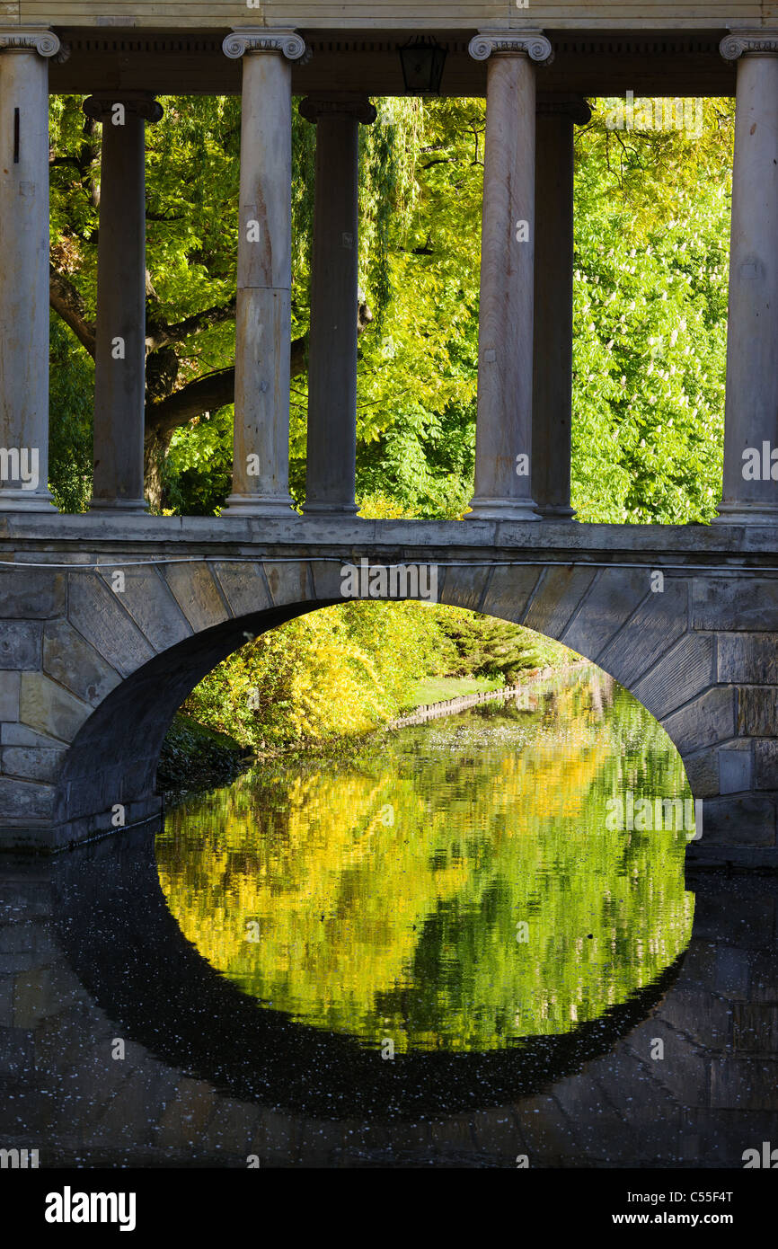 Riflessioni su acqua sotto un vecchio ponte di arco con colonne nel Parco Lazienki a Varsavia, Polonia Foto Stock