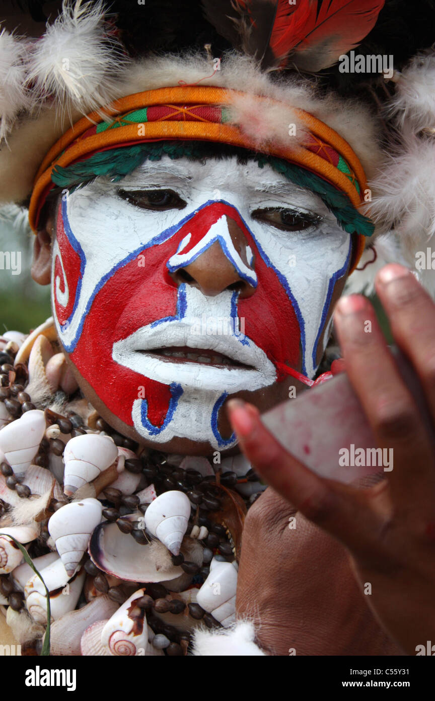 Un Tribeswoman di Papua Nuova Guinea dipinto il suo volto Foto Stock