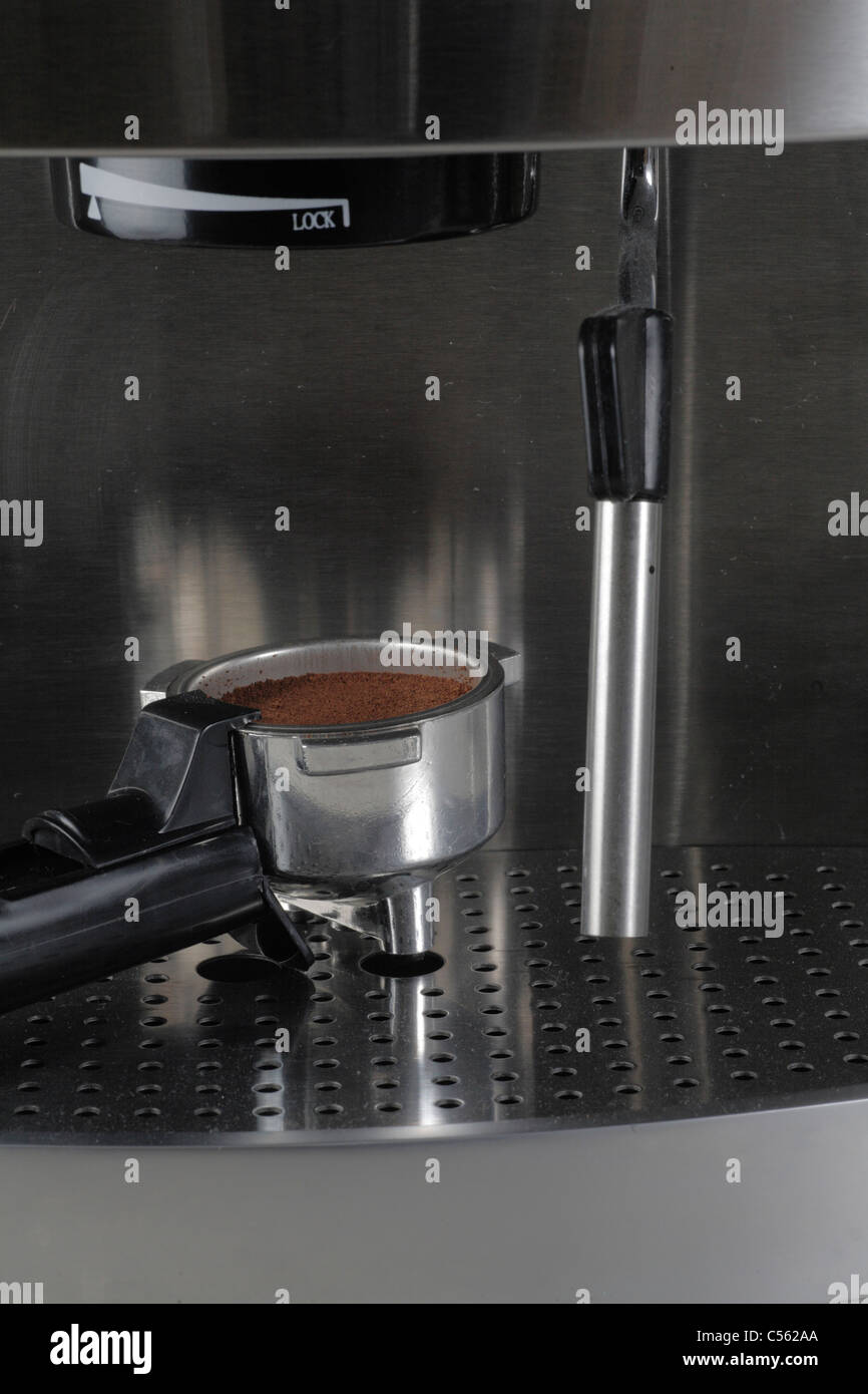 Portafiltro o portafilter casa espresso expresso maker riempito con caffè appena macinato e lancia vapore Foto Stock