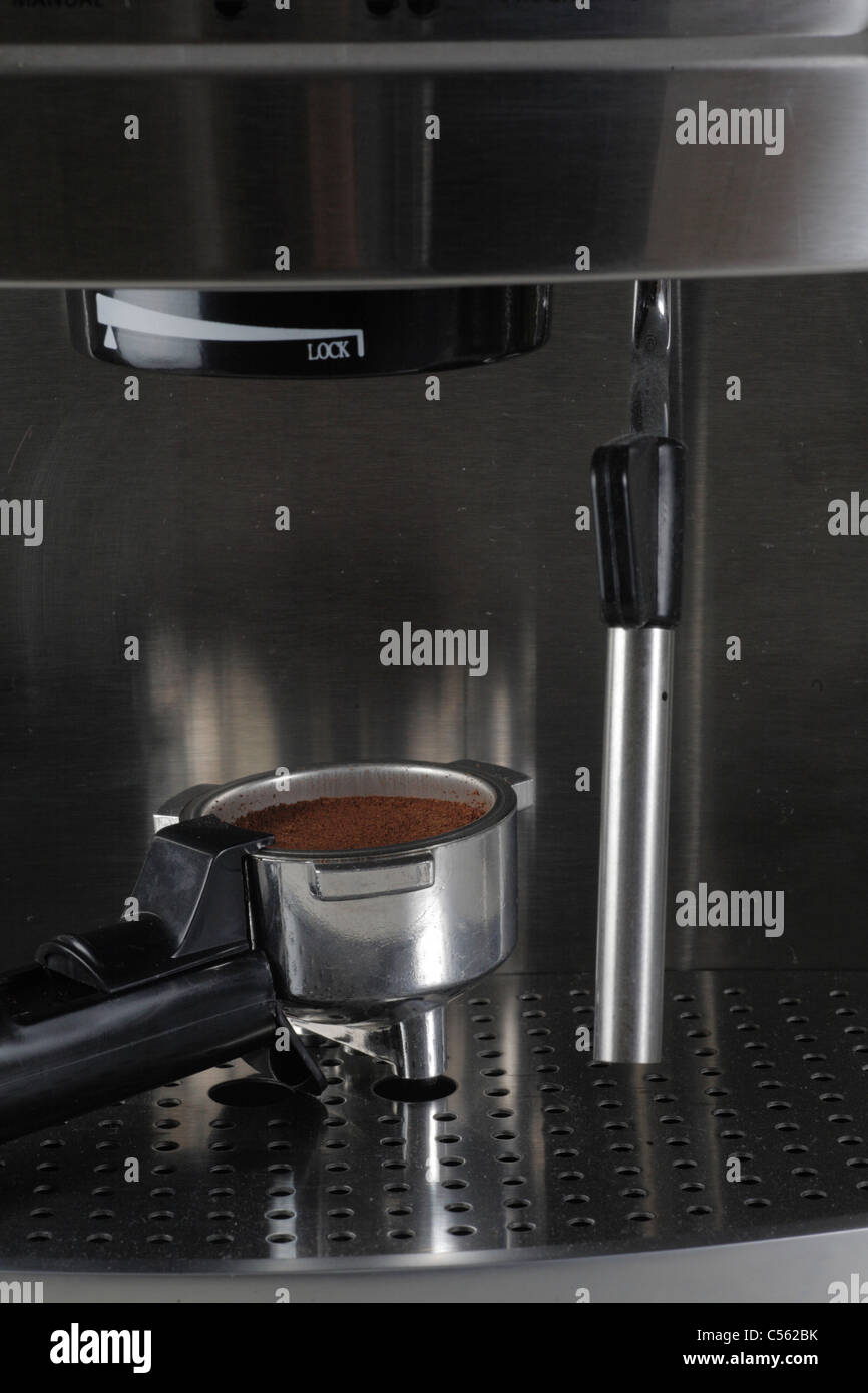 Portafiltro o portafilter casa espresso expresso maker riempito con caffè appena macinato e lancia vapore frother latte Foto Stock