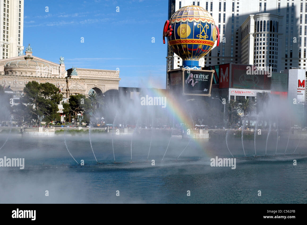 Un arcobaleno compare nella nebbia di Bellagio fontana sulla Strip di Las Vegas. Attraverso la striscia è il Paris Las Vegas segno. Foto Stock