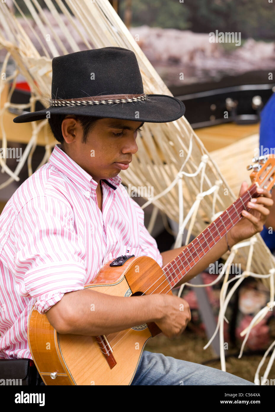 Una giovane indigena uomo colombiano suona la chitarra Foto Stock