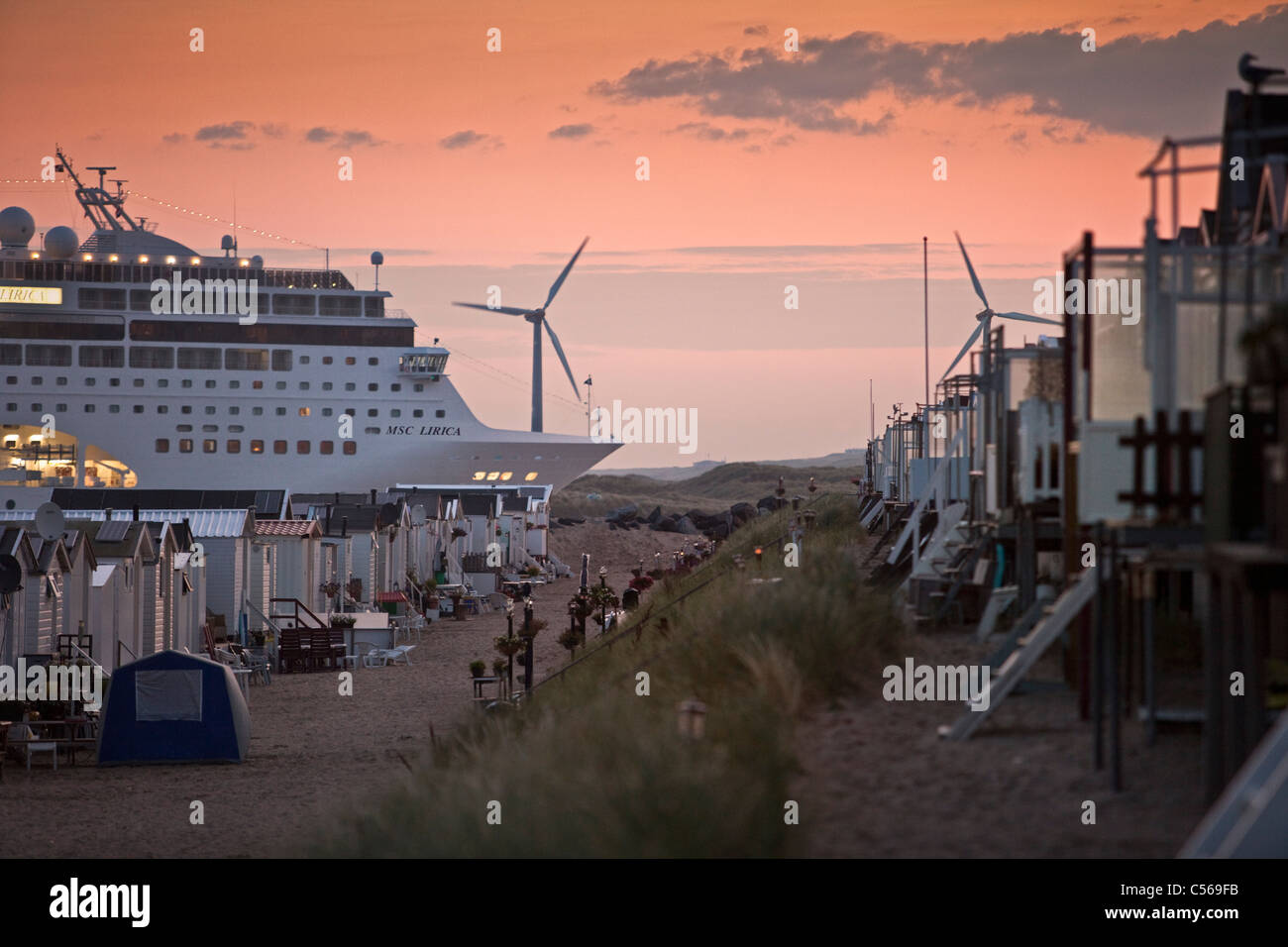 I Paesi Bassi, IJmuiden, nave da crociera che arrivano al mare del Nord Canal. Sunrise. Cabine da spiaggia. Foto Stock
