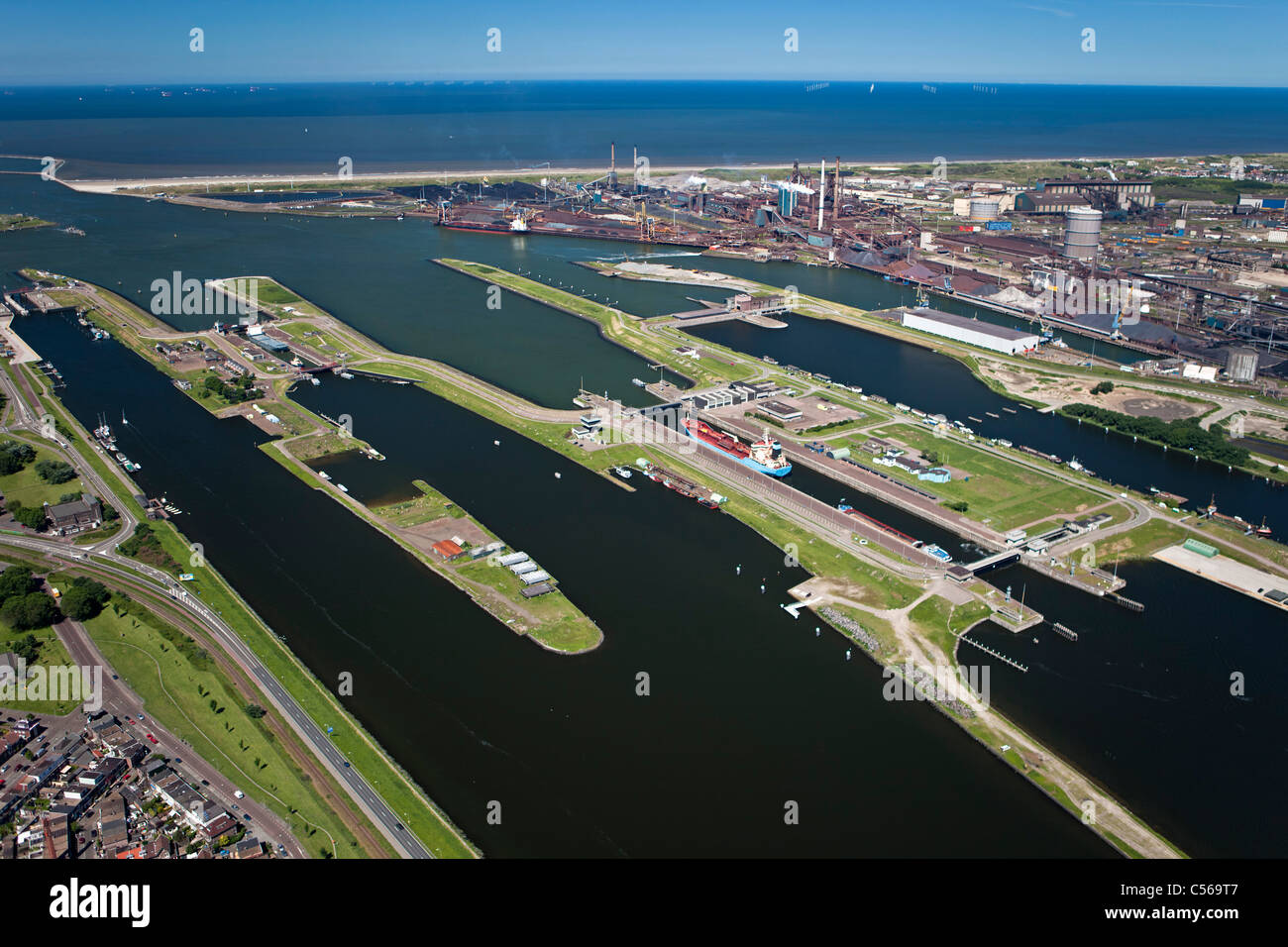 I Paesi Bassi, IJmuiden, vista aerea di entrata e serrature del Mare del Nord Canal. Diritto Tata Steel factory. Foto Stock