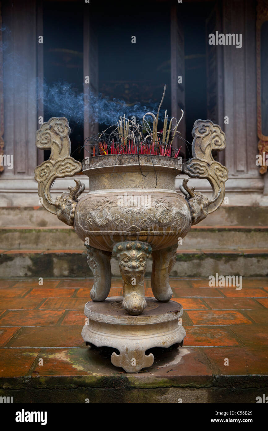 Tempio buddista incenso joss bastoncini di fumare nell'offerta di pentola, Vietnam Foto Stock