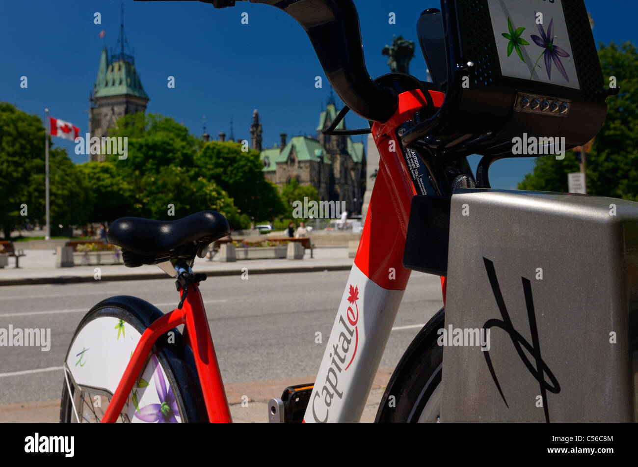 Bixi il trasporto della bicicletta a Ottawa la capitale nazionale con il Parlamento Buldings Canada con la bandiera canadese Foto Stock