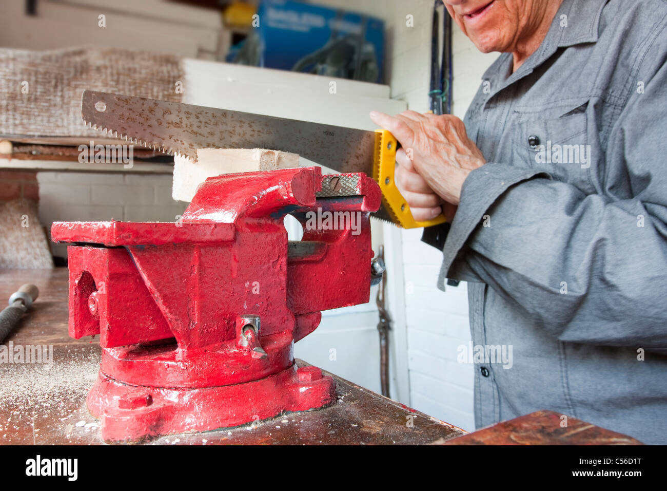 Uomo al lavoro nel suo capannone workshop con il vicino sul vice Foto Stock