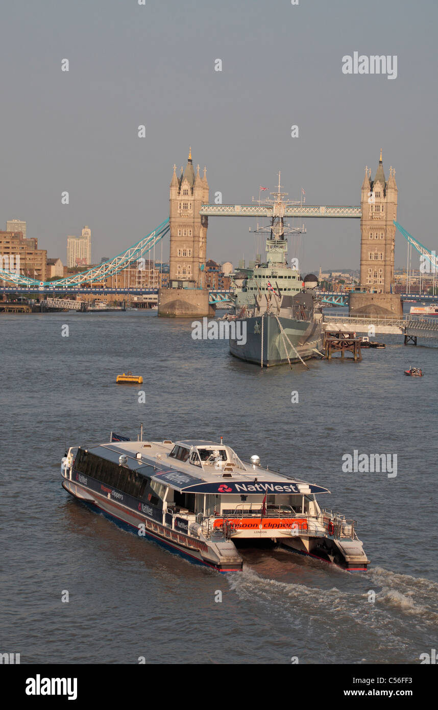 Crociera sul fiume in direzione dell'incrociatore della seconda guerra mondiale HMS Belfast e Tower Bridge, River Thames, Londra. Foto Stock