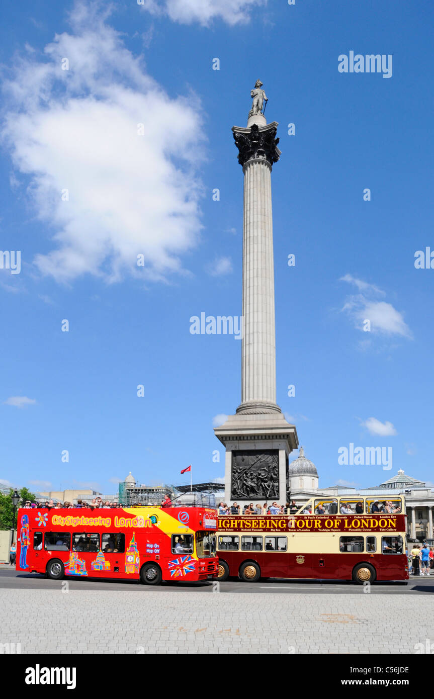 I turisti di scena di strada di Londra su una visita turistica a due piani Gli autobus del tour passano la colonna di Nelsons blu cielo giorno estivo Trafalgar Square Inghilterra Regno Unito Foto Stock